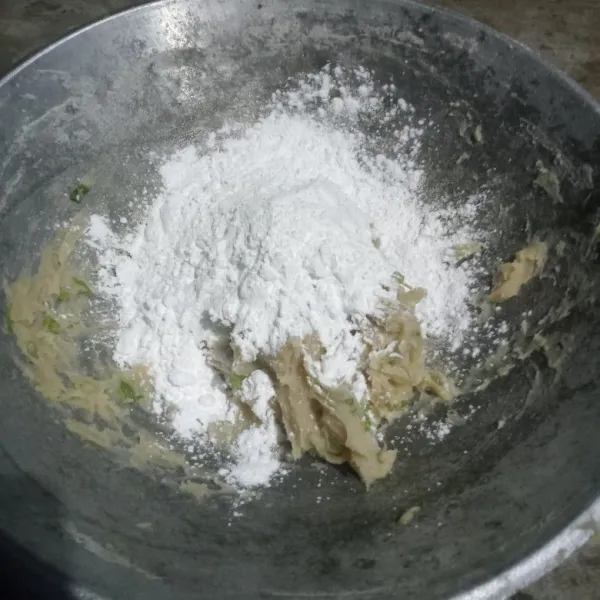 Tuangkan tepung tapioka dan uleni sampai rata.