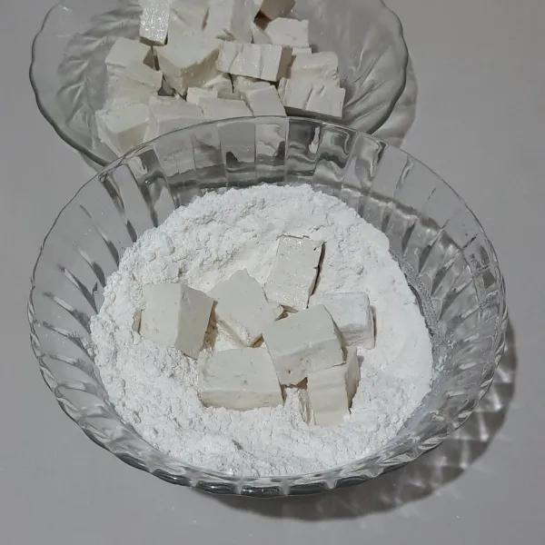 Lumuri tahu yang sudah di potong-potong, lalu campurkan ke 2 tepung dan tambahkan garam, aduk rata. Masukkan tahu balur tepung.