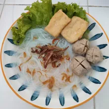 Tata bihun dalam piring saji, tambahkan bahan pelengkap lainnya lalu sajikan.