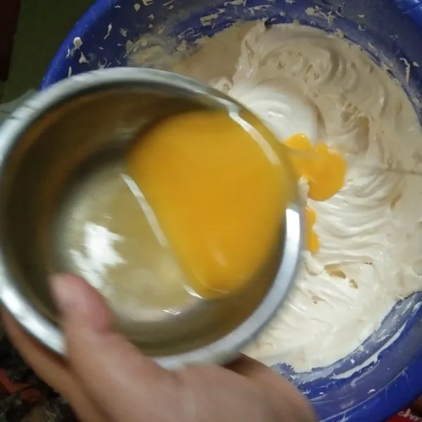Masukan lelehan mentega, aduk dengan spatula menggunakan teknik aduk balik hingga tercampur rata.