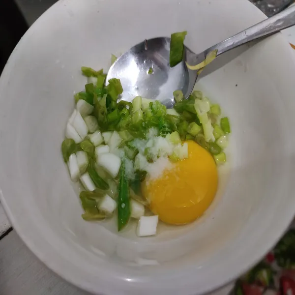 Kocok lepas telur dengan daun bawang dan kaldu bubuk.