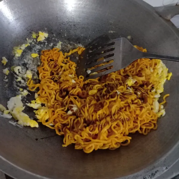 Masukkan mi, tambahkan kecap manis, kecap asin.