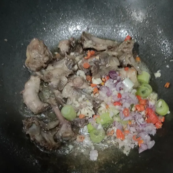 Beri minyak goreng, sambil diaduk sampai tulangan setengah matang. Lalu masukan irisan bawang merah, bawang putih, cabe dan batang daun bawang. Tumis sampai harum.