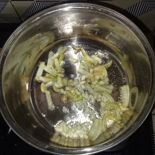 Potong-potong bawang bombay dan cincang bawang putih, lalu tumis hingga harum.