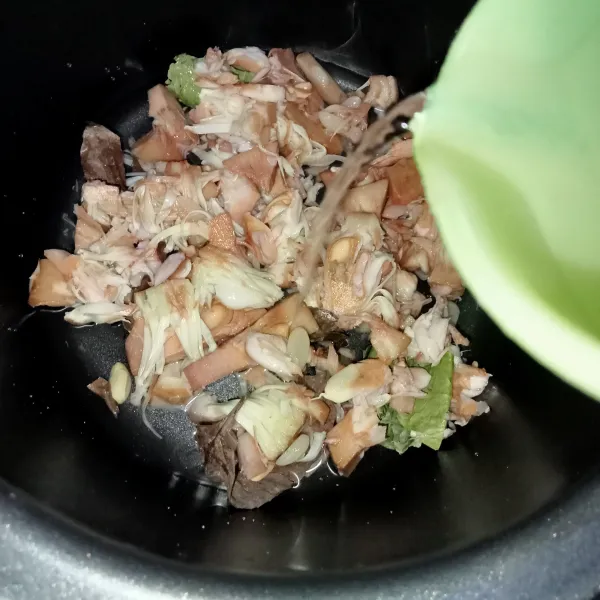 Tata daun salam di dalam panci kemudian letakkan nangka di atasnya kemudian tuang air.