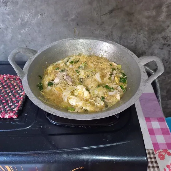 Masukkan bihun, daun bawang dan seledri. Bumbui dengan garam, gula, penyedap rasa dan kecap manis lalu koreksi rasa. Masak sebentar saja lalu angkat