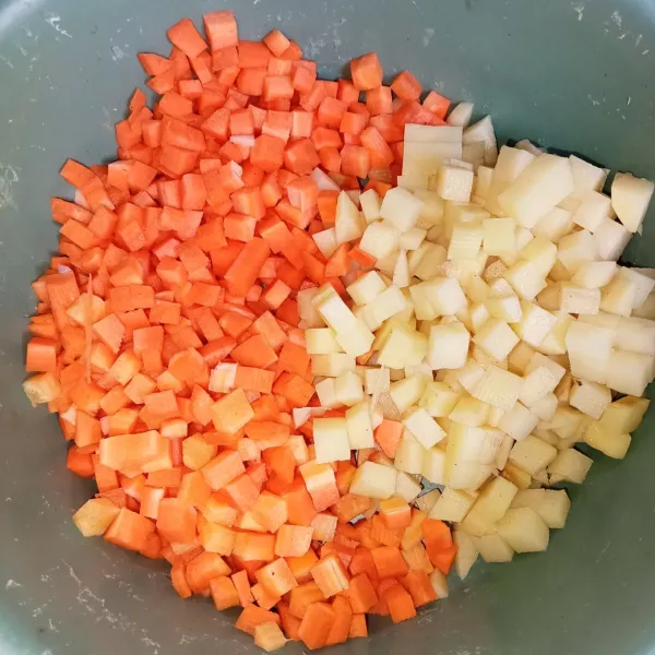 Kupas kentang dan wortel, lalu potong kotak kecil.