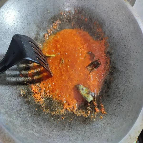 Tumis bumbu halus dengan minyak sisa menggoreng ayam. Kemudian tambahkan daun jeruk dan daun salam, lalu aduk rata.