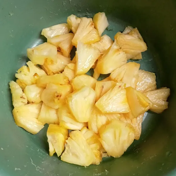Kupas dan potong-potong buah nanas.