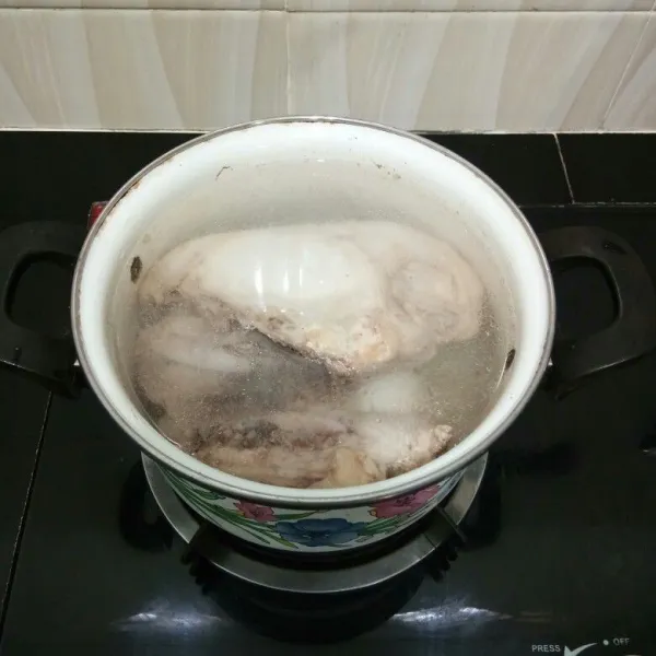 Rebus ayam dengan secukupnya air hingga mendidih sesaat, lalu buang airnya. Kemudian rebus kembali dengan air baru hingga mendidih kembali.