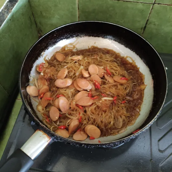 Masukkan soun, lalu beri kecap manis, saus tiram, garam, kaldu bubuk, merica bubuk, dan gula pasir. Lalu aduk merata hingga meresap.