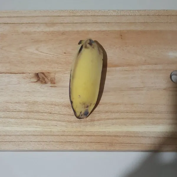 Siapkan pisang, lalu belah jadi 2 bagian.