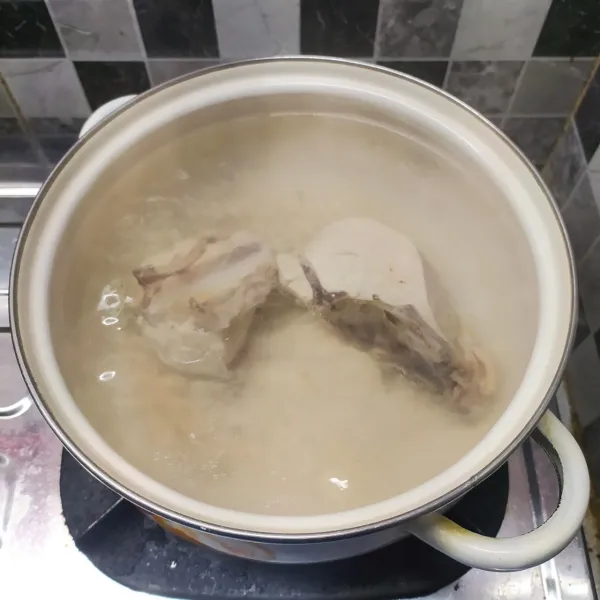 Rebus air secukupnya sampai mendidih. Masukkan ayam, masak sampai keluar kotoran dan busanya. Buang air rebusan, kemudian ganti dengan air yang baru. Masak dengan api kecil sampai keluar minyak dari ayam.