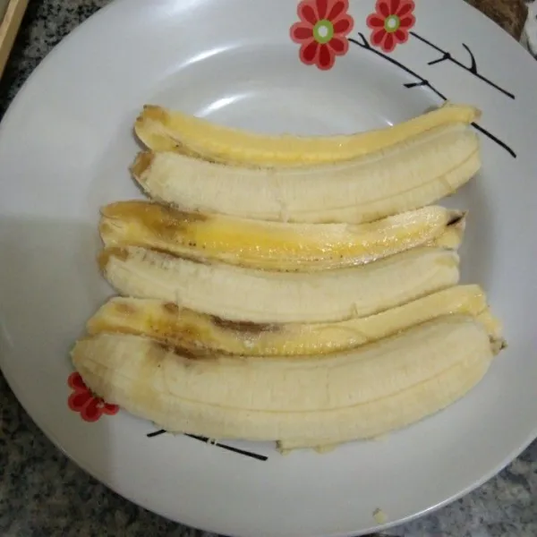Belah memanjang pisang menjadi 2 bagian.