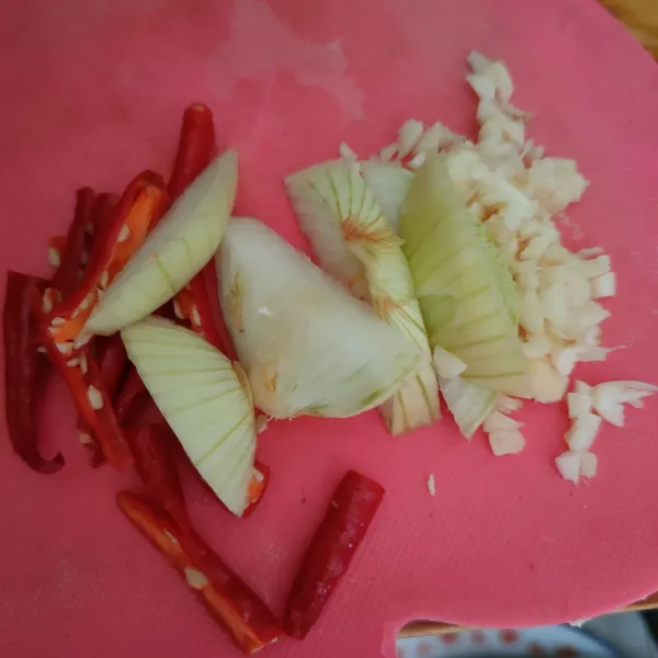 Cincang bawang putih, potong bawang bombay dan cabai merah keriting.