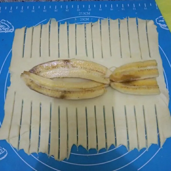 Kerat-kerat pinggiran kulit pastry, letakkan pisang di bagian tengahnya.