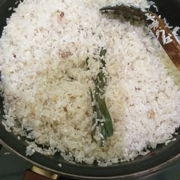 Masukkan beras dan garam, aduk rata dan tumis sebentar sampai bumbu terserap di beras. Matikan api.