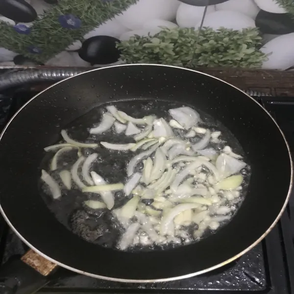 Setelah minyak panas, tumis bawang putih dan daun bawang hingga layu.
