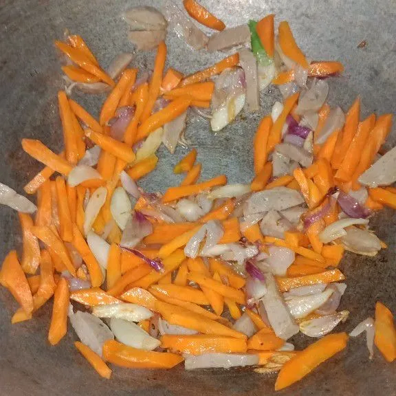 Masukan potongan wortel dan bakso, aduk rata. Beri air dan merica bubuk, masak hingga air menyusut dan wortel empuk.