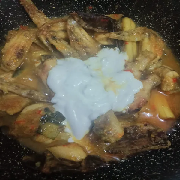 Masukkan santan dan aduk rata. Beri garam, masako, gula pasir, dan sedikit kecap manis. Cicipi rasanya, masak hingga air menyusut dan bumbu telah merasuk ke daging ayam.