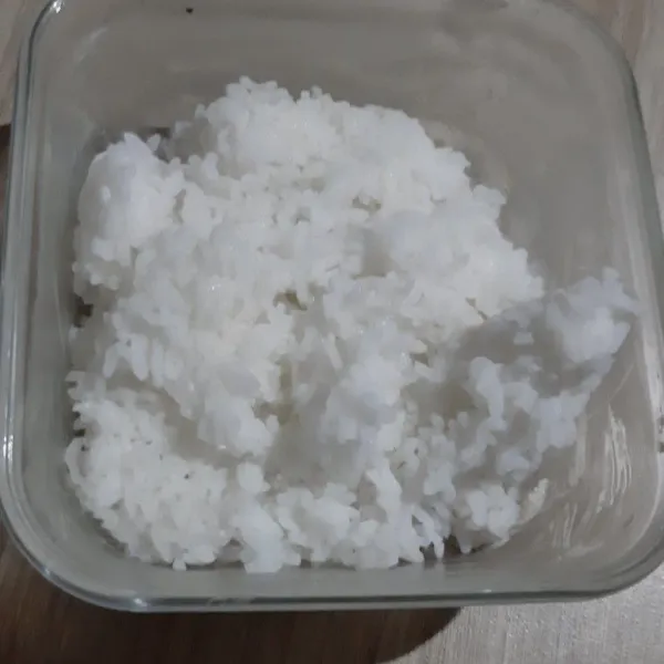 Siapkan 1 piring nasi lalu kipasi untuk hilangkan uapnya.
