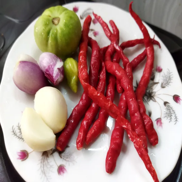 Petik cabe, kupas bawang lalu cuci bersama tomat, tiriskan.