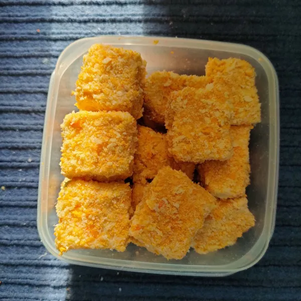 Lapisi nugget merata ke bahan pelapis, kemudian lapisi dengan tepung panir.