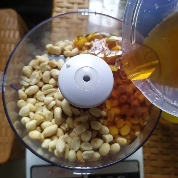 Tempatkan kacang ke dalam blender, tambahkan madu.
