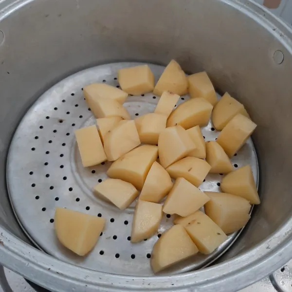 Kupas kentang, cuci bersih lalu kukus hingga matang.