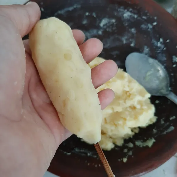 Ambil sedikit adonan kentang, lalu beri isian sosis. Kepal-kepal.