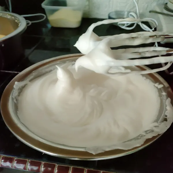 Mixer putih telur dengan kecepatan sedang, jika sudah berbuih masukkan cream of tartar. Lalu tambahkan gula pasir secara bertahap, mixer hingga soft peak. Sisihkan.