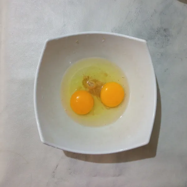 Dalam wadah, masukkan telur, garam dan lada bubuk, lalu kocok.