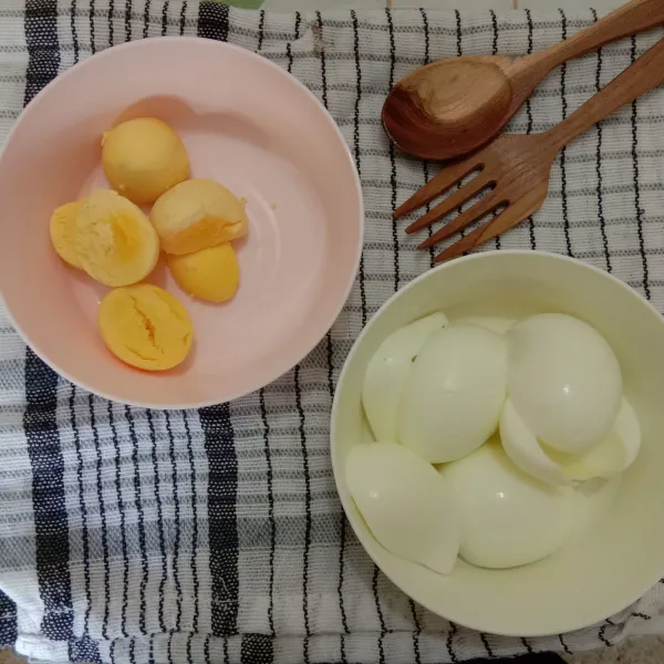 Rebus telur ayam dan pisahkan antara kuning telur dan putih telur.
