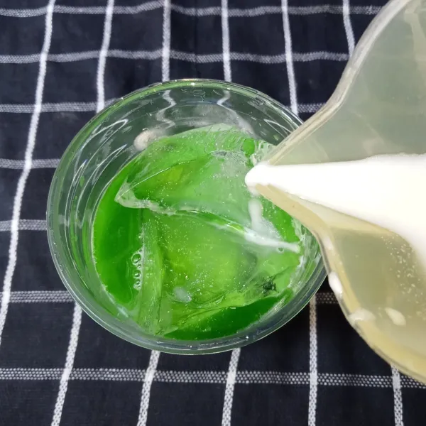 Masukkan es batu, lalu tuang susu cair hingga terisi 3/4 gelas.