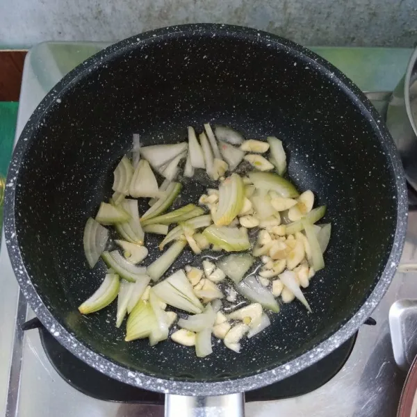 Tumis bawang bombay dan bawang putih sampai harum dan layu.