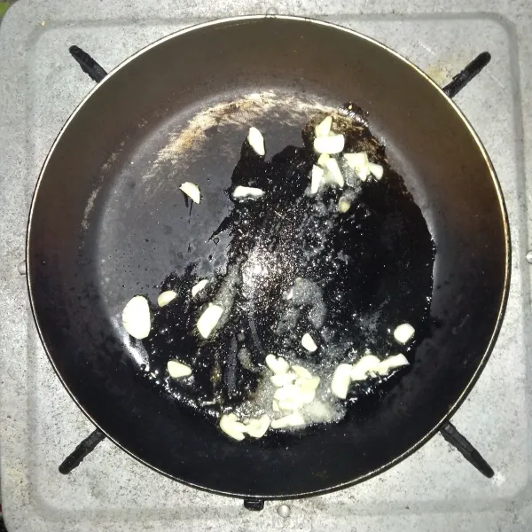 Panaskan minyak, tumis irisan bawang putih hingga harum.