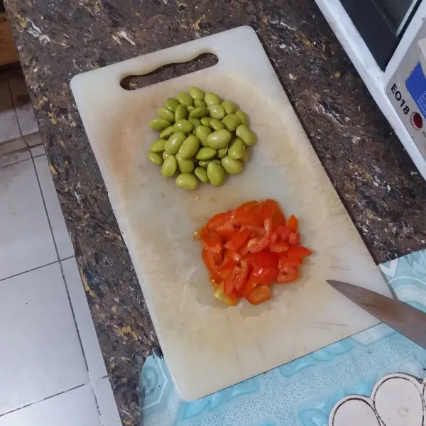 Kukus kacang edamame hingga matang, potong tomat cherry kecil-kecil.