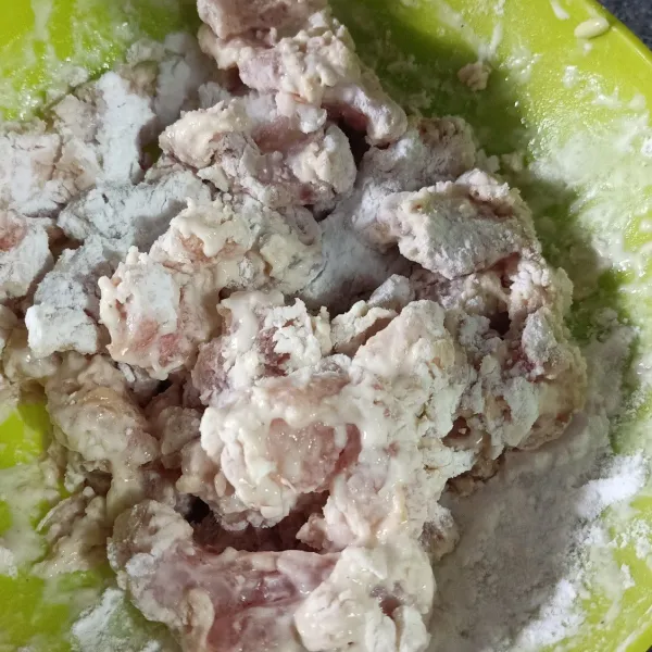 Masukkan ayam ke dalam tepung serba guna yang telah dilarutkan dengan air kemudian masukkan kembali ke tepung serbaguna yang kering, aduk rata.