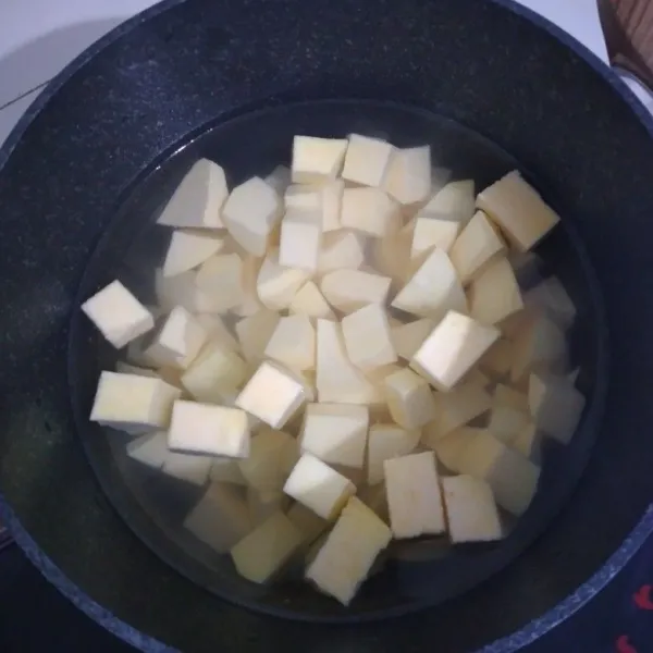 Panaskan air, setelah mendidih masukkan ubi yang sudah dipotong-potong. Rebus setengah matang.