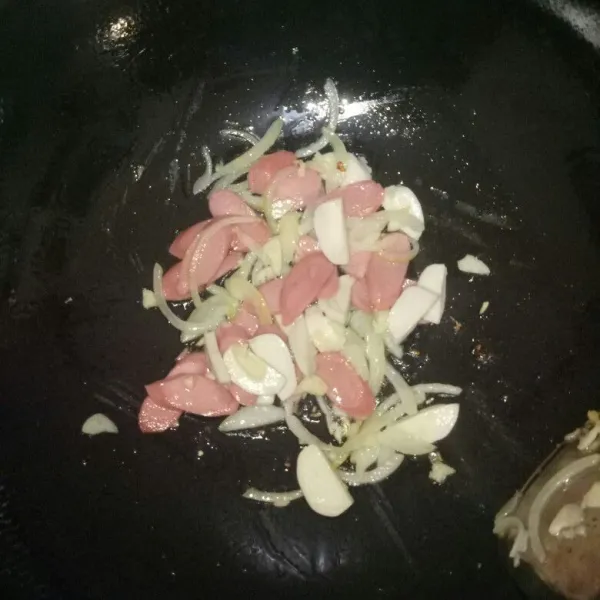 Siapkan pan dan panaskan minyak.Tumis bawang putih dan bawang bombay sampai harum,kemudian masukan bakso ikan dan sosis.Aduk rata