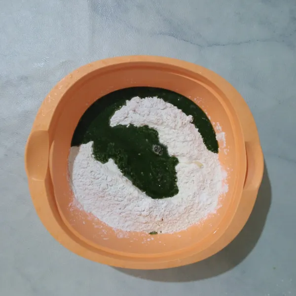 Tuangkan sari daun kelor sedikit demi sedikit sambil terus diaduk hingga adonan kalis ( kebutuhan air dapat berbeda-beda bergantung dengan daya serap tepung).