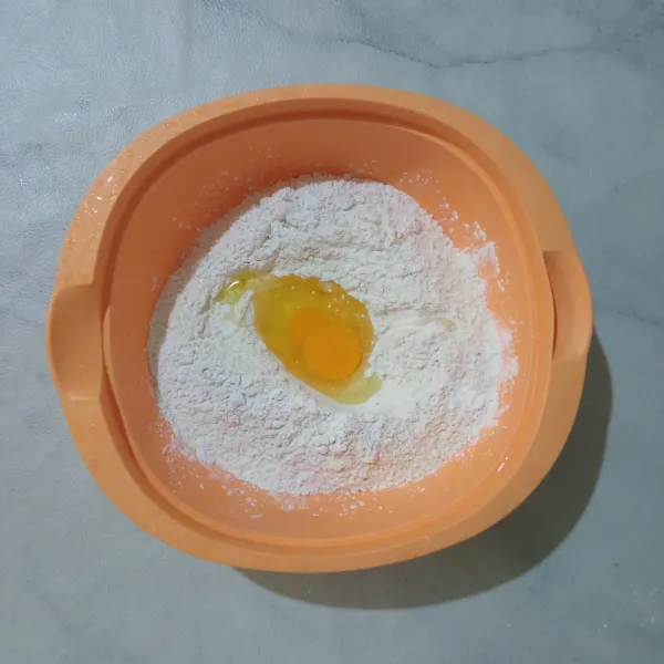 Campurkan tepung terigu, tepung tapioka, dan garam. Tambahkan telur di tengahnya.