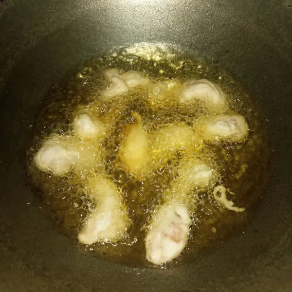 Panaskan minyak dengan api sedang. Celupkan ayam ke adonan tepung basah lalu langsung masukkan ke minyak satu persatu. Goreng sampai matang.