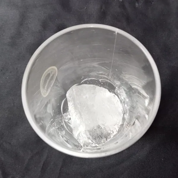 Siapkan gelas air masukkan es batu secukupnya.