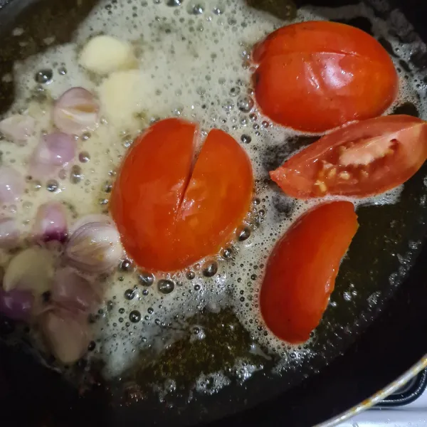 Panaskan minyak goreng, masukkan tomat yang telah dipotong, bawang merah, dan bawang putih.