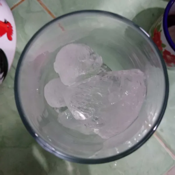Masukkan es batu dalam gelas lalu tuang sirup telang.