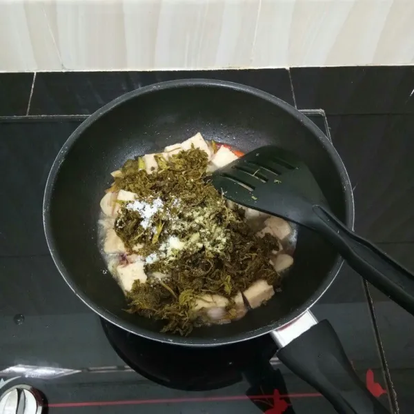Kemudian masukkan daun kenikir, kaldu bubuk, gula pasir, dan garam, lalu aduk rata.