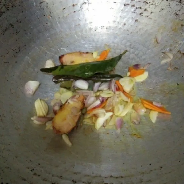 Tumis irisan bawang putih, bawang merah, daun salam, kunyit, dan lengkuas hingga harum.