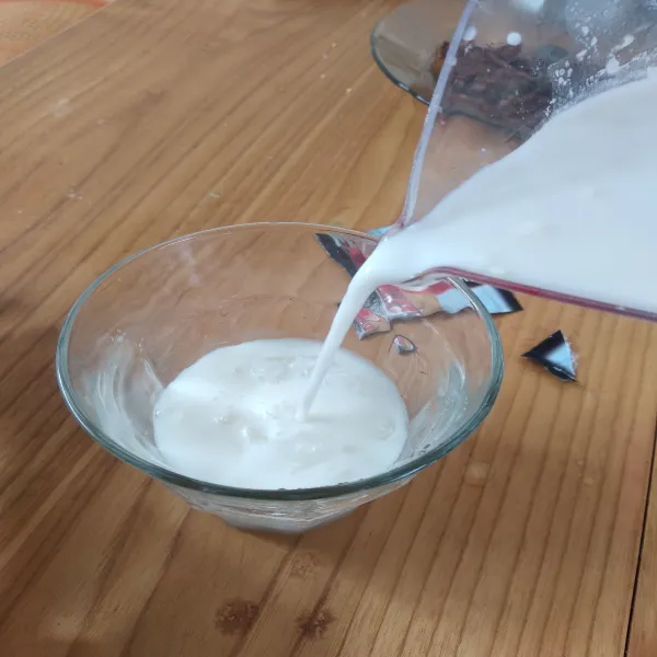 Tuang susu ke dalam gelas berisi es batu