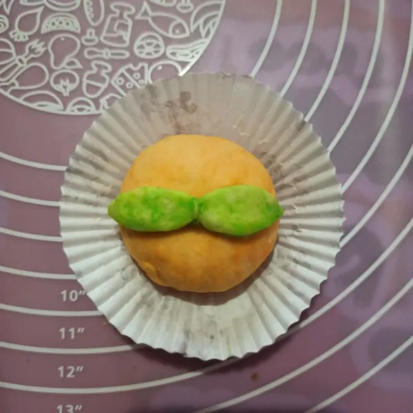 Bulatkan adonan, kemudian letakkan di cup/ kertas roti. Beri daun-daunan.